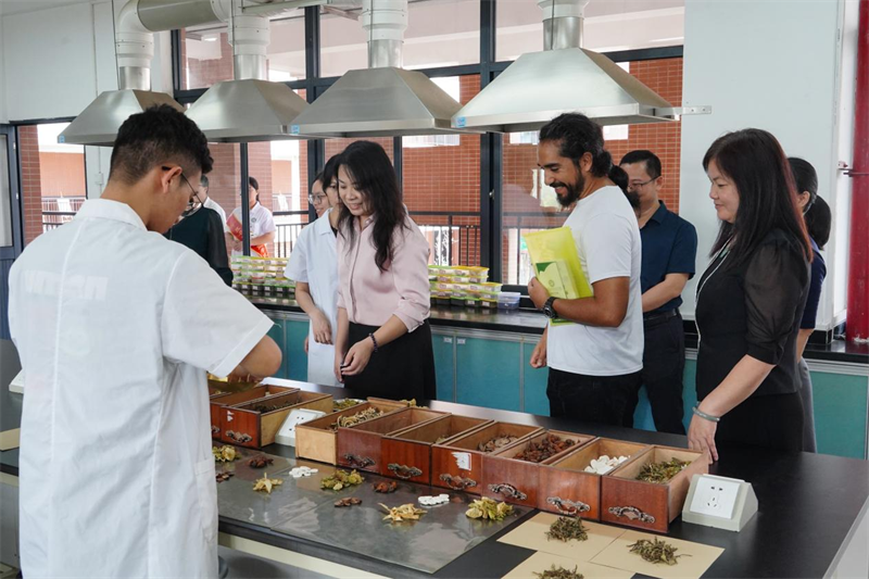 图为专家调研组体验中药炮制项目.png